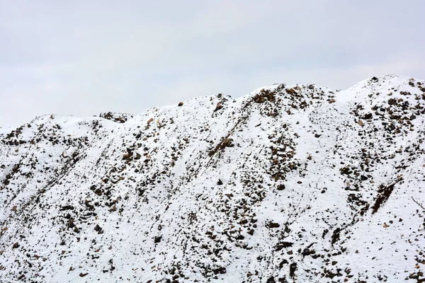 明るくカラフルな高い山 ピーク 急な丘は道路に沿って位置しており 冬には薄い白い雪で覆われています 灰色の白い空に対する非常に興味深いと妖艶な風景 — ストック写真