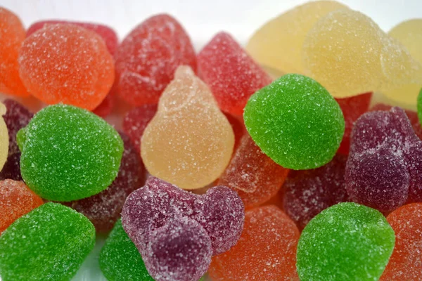 Beautiful bright and colorful sweet candies made from natural fruit juice in the form of jelly and sugar. Multi-colored sweets in the form of fruits of different colors: red, yellow, green, orange, cherry.