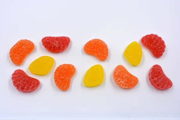 Beautiful and colorful sweet jelly candies made from natural juice in the form of natural fruits: pears, apples, raspberries, orange slices, watermelon and lemon.