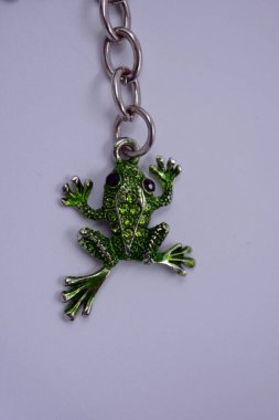 Küçük yeşil kurbağalarla süslenmiş güzel, parlak bir anahtarlık, küçük yeşil taşlı kurbağalar. Anahtarları dekore eden üç küçük kurbağadan oluşan metal bir zincirin mücevherleri..