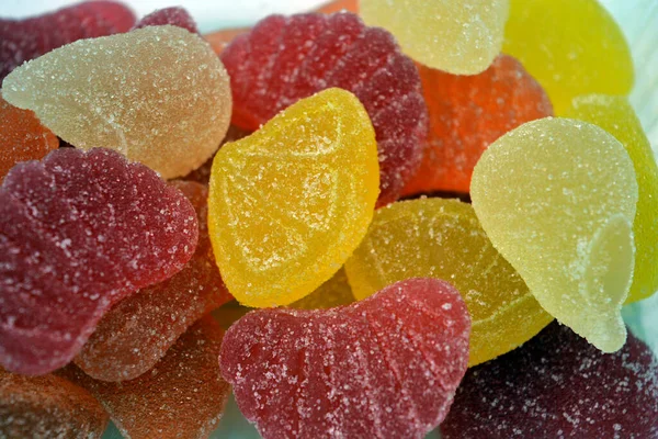 Beautiful bright and colorful sweet candies made from natural fruit juice in the form of jelly and sugar. Multi-colored sweets in the form of fruits of different colors: red, yellow, green, orange, cherry.