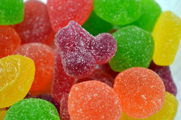 Beautiful bright and colorful sweet candies made from natural fruit juice in the form of jelly and sugar. Multi-colored sweets in the form of fruits of different colors: red, yellow, green, orange, cherry.