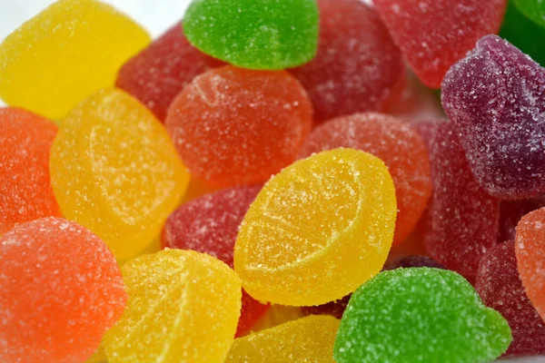 Beautiful bright and colorful sweet candies made from natural fruit juice in the form of jelly and sugar. Multi-colored sweets in the form of fruits of different colors: red, yellow, green, orange, cherry.