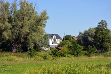 Bright, doll-like, stylish houses, private buildings are located around the amazing nature, the Bug River in the village of Ribenko-Nova of Gmina Wyszkw, within Wyszkw County, Masovian Voivodeship, in east-central Poland.
