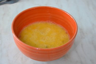 Healthy food, scrambled eggs poured in an orange clay plate.