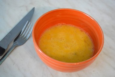 Healthy food, scrambled eggs poured in an orange clay plate.