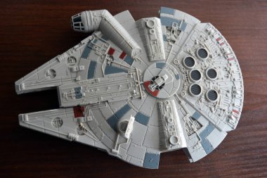 A huge gray spaceship of the future with instruments and equipment is located on a dark brown wooden background. Large unidentified flying object on the latest technology.