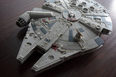A huge gray spaceship of the future with instruments and equipment is located on a dark brown wooden background. Large unidentified flying object on the latest technology.