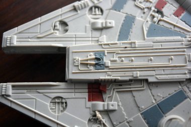 A huge gray spaceship of the future with instruments and equipment is located on a dark brown wooden background. Large unidentified flying object on the latest technology.