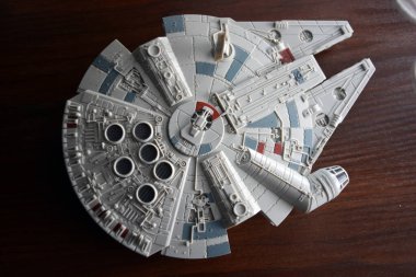 A huge gray spaceship of the future with instruments and equipment is located on a dark brown wooden background. Large unidentified flying object on the latest technology.