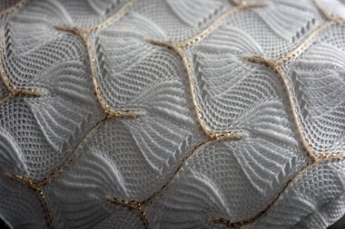 Beautiful white woven fabric with an intriguing pattern of dense white threads and fine gold threads. Beautiful thin gossamer weaving, luxurious fabric, expensive and exclusive fabric.