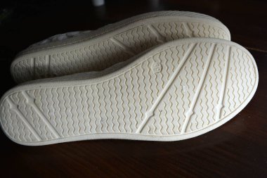 Women's summer shoes made of natural woven fabric with white flat soles. White light fashionable and stylish moccasins decorated with thin gold thread look very long and stylish.