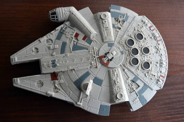 A huge gray spaceship of the future with instruments and equipment is located on a dark brown wooden background. Large unidentified flying object on the latest technology.