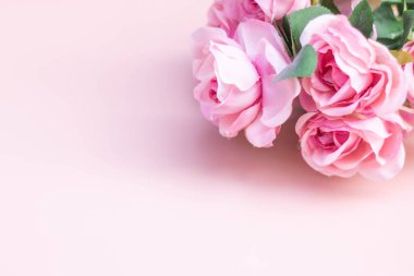 Açık pembe arkaplanda pembe gül buketi.