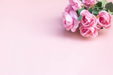 Açık pembe arkaplanda pembe gül buketi.