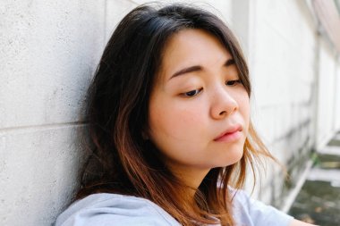 Dışarıda oturan genç ve güzel Asyalı kadını yakından çek..