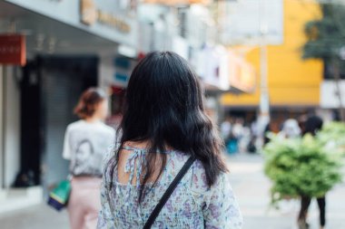 Close up of beautiful Asian woman with city blurred background.