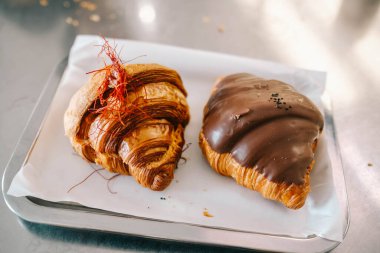 Freshly baked croissants with chocolate dip on the tray, brunch at coffee shop.