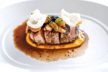 Domuz pirzolası soslu beyaz tabakta servis edilir..