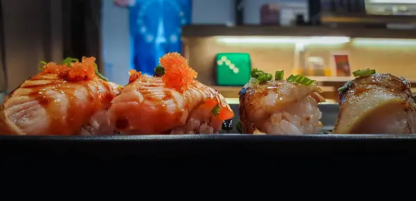 Japon yemekleri farklı türde suşi ile deniz yosunu salatası ve gari (zencefil) Japon restoranındaki servis panosunun sağ üst kısmında bulunan sağlıklı bir yemektir.