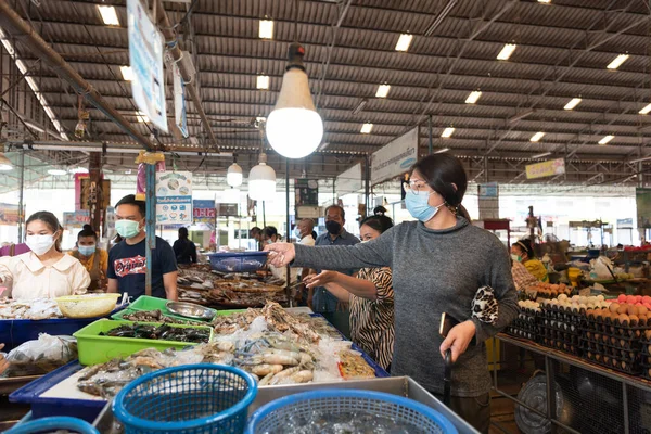 Suphanburi, Tayland - 30 Ekim 2021: Kimliği belirlenemeyen kadın Tayland sokak gıda pazarından alışveriş yaparak ucuz fiyata sebze ve meyve satın alabilir.
