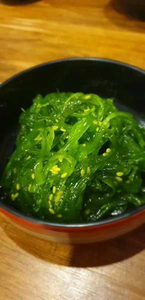 Japon yemekleri farklı türde suşi ile deniz yosunu salatası ve gari (zencefil) Japon restoranındaki servis panosunun sağ üst kısmında bulunan sağlıklı bir yemektir.