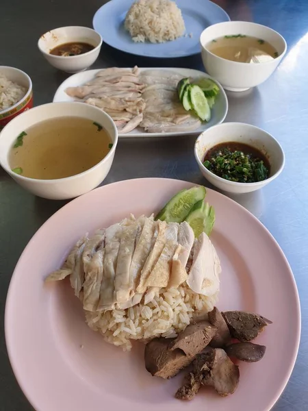 Tavuk çorbası (hainanese tavuğu pilavı) ve salatalık, ciğer ve sos ile buğulanmış pirinç Bangkok Tayland 'daki Tayland sokak yiyecek pazarında veya restoranda satılmaktadır.