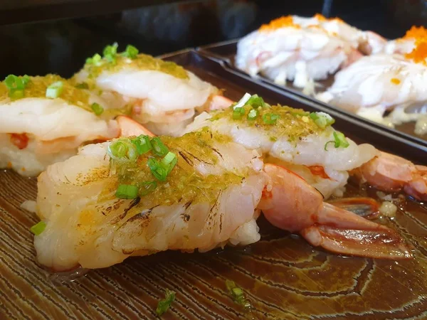 Japanese food in set different types of sushi with seaweed salad and gari (ginger) is a healthy food at the upper right of the serving board in japan restaurant