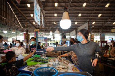 Suphanburi, Tayland - 30 Ekim 2021: Kimliği belirlenemeyen kadın Tayland sokak gıda pazarından alışveriş yaparak ucuz fiyata sebze ve meyve satın alabilir.