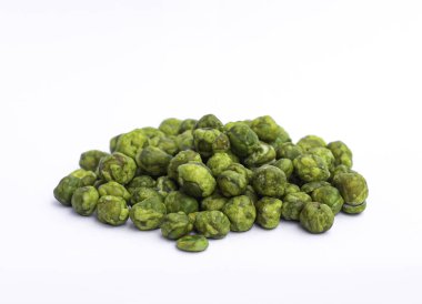 Yakın plan seçilmiş yeşil bezelyeli bezelye yığını, beyaz arka planda tuzlu, kızarmış ve çıtır çıtır bir atıştırmalıktır..