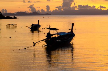 Gündoğumunda Adang-Ravi Adası, Tarutao Ulusal Parkı, Satun Tayland 'da denizde uzun kuyruklu bir tekne..