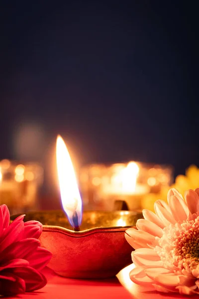 幸せなディワリ インドの光の祭りの伝統的なシンボル 赤い背景にダイヤオイルランプや花を燃やす コピースペース 垂直写真 — ストック写真