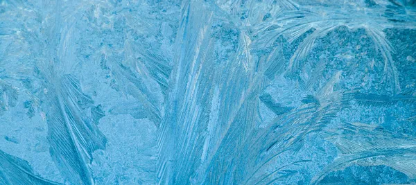 Patrones helados en vidrio. Fondo de Navidad. Hielo en la ventana de invierno. Cristales abstractos de cerca. — Foto de Stock