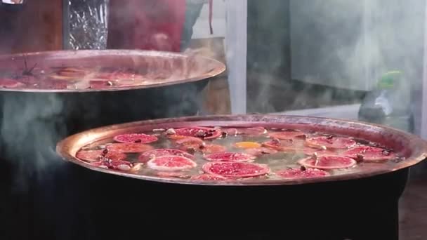 Glühweinzubereitung. Streetfood auf dem Weihnachtsmarkt. Warmes Wintergetränk mit Früchten, Beeren und Zimt. — Stockvideo