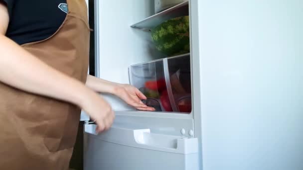 Mulher tira pimentão vermelho fresco da geladeira. Cozinhar comida saudável em casa cozinha. Estilo de vida ecológico. — Vídeo de Stock