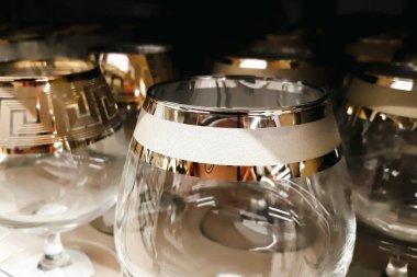 Bir sürü cam bardak var. Cam üretimi. Fabrikada dekoratif jantlı boş bardaklar. Mağazada sofra takımı satılıyor.