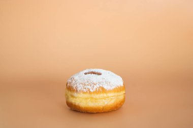 Mutlu Hanukkah. Geleneksel Yahudi tatlı Sufganiyot. Musevilik bayramını kutluyoruz. Reçelli çörek ve bej arkaplanda şeker tozu.