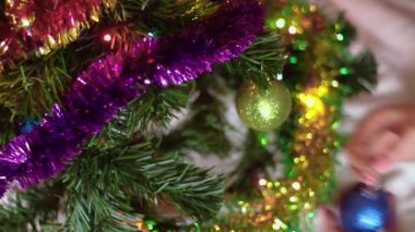 Kadın Noel ağacını süslüyor. Kadın elleri Noel toplarını ve dekorasyonu tutuyor. Tatilin kutlaması. Çevre dostu yapay ladin..