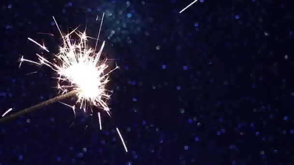 Brilhante sparkler em fundo azul brilhante. Véspera de Ano Novo festa festiva. — Vídeo de Stock