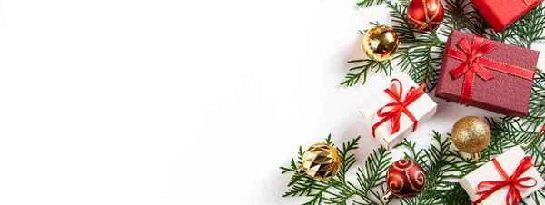 Подарункові коробки з червоною стрічкою та золотими різдвяними кульками на білому тлі . — стокове фото