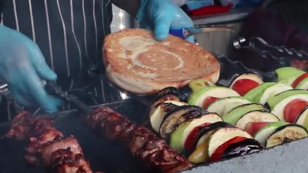 Cocinar comida callejera. Chef masculino en guantes prepara carne a la parrilla y verduras. — Vídeos de Stock