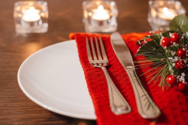 Noel sofrası. Tabak ve çatal bıçak takımı peçeteye. Şenlik yemeğine hazırlanıyorum. Noel arifesinde mumlar yanıyor..