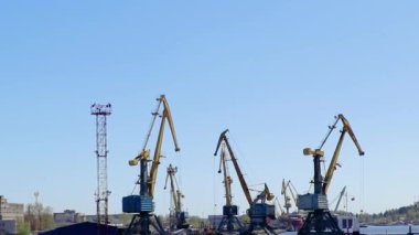 Liman vinçleri nakliye limanında. Lojistik ve kargo teslimatı. Nakliye konteynerleri yükleniyor. İş konsepti, sanayi sahnesi.
