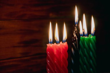 Mutlu Kwanzaa 'lar. Afro-Amerikan tatili. Yedi yanan mum, kırmızı, siyah ve yeşil, Kinara şamdanında. Afrika mirasının sembolleri.
