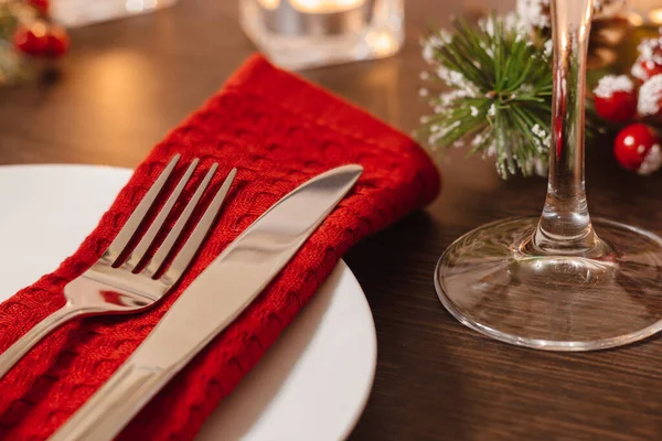 クリスマステーブルのセッティング ナプキンにプレートとカトラリー お祝いの夕食の準備 クリスマスの夜にテーブルの上で燃えるキャンドル ロイヤリティフリーのストック画像