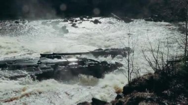 Taşların arasındaki dağ fırtınalı nehir. Güçlü nehir akışı. Dağlarda köpüklü ve köpüklü su. Tehlikeli bahar seli, iklim değişikliği.