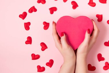 Kadın elleri büyük pembe bir kalp tutuyor. Sevgililer Günü konsepti, metin yeri