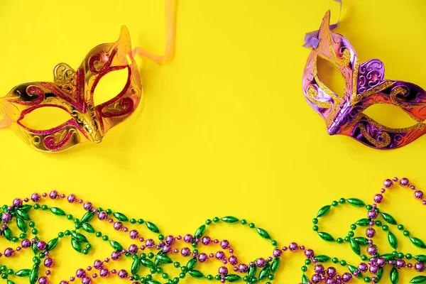Две Разноцветные Карнавальные Маски Бусины Желтом Фоне Концепция Марди Гра — стоковое фото