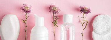 Pembe arka planda kozmetik ürünler. Sabun, losyon ve pamuk pedler. Spa aksesuarları. Refah kavramı.