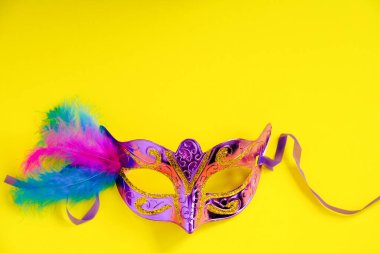 Sarı arka planda karnaval maskesi. Mardi Gras konsepti. Şişman Salı sembolü. Boşluğu kopyala.